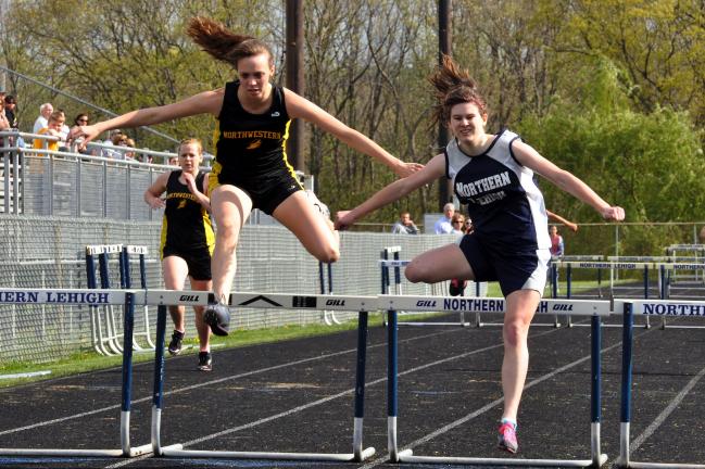 mike feifel/times news Northwestern's Natalie Hill and Northern Lehigh's Gina Krupa (right) clear the final hurdle in the 300. They finished tied for first in the event.