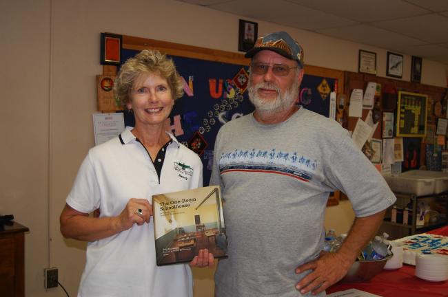 Nancy Thatcher of the Lehigh Township Historical Society accepts a book, "The One-room Schoolhouse," from Lenny Szy of the Lower Saucon Historical Society.