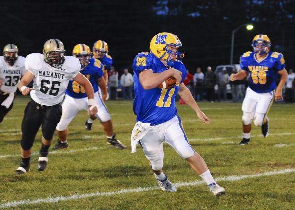 Steve Shinko/TIMES NEWS Marian's Corey Quick looks looks for running room as Mahanoy Area's Taylor Pecika (65) closes in from behind during Friday night football action at Marian.