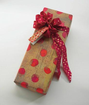 AP PHOTO/JON VAN GORDER This product imageshows brightly dotted paper complimented by a ribbon with smaller dots, a creation by Susan Swan from the book "Wrapped with Style," Universe Publishing, 2009. A gift-giver's thoughtfulness is as apparent in…