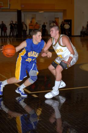 ron gower/times news Marian's Ryan Gimbi (left) drives to the basket against Mahanoy Area's Jim Wagner.