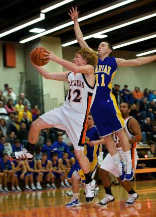 bob ford/times news Weatherly's George Wallish drives hard to the basket as Marian's Chris Barletta defends.