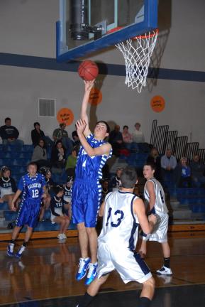 RON GOWER/TIMES NEWS Palmerton's Ben Andrews goes up to lay one off the glass as Tamaqua's Zach Lakitsky (13) looks on. Andrews finished with 15 points as the Bombers pulled out a 59-55 win.