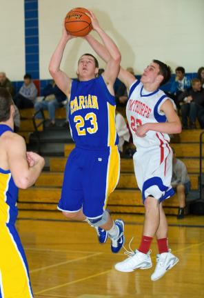bob ford/times news Marian's Ryan Gimbi (23) goes up with a shot as Dane Ciavarella defends for Jim Thorpe.