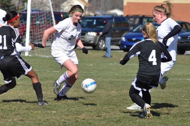 ron gower/times news Northwestern's Emily Iobst (21) tries to split Saucon Valley defenders Quanie Lightner (left) and Andie Evans (4). Also moving into the play is the Tigers' Aubrey Kehs (9).