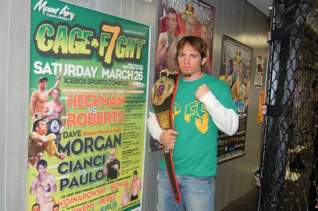 Professional MMA fighter Joel Roberts of Lehighton poses with the PA Cage Fighting Professional Featherweight Title he won recently at the Ice Box Arena in Scranton.
