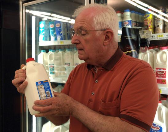AL ZAGOFSKY/SPECIAL TO THE TIME NEWS Frank Pasdon, owner of the Jim Thorpe Market, checks "Sell By" date on milk container. His employees remove milk that reaches its "Sell By" date, which is rare as fresh milk is delivered three times per week.