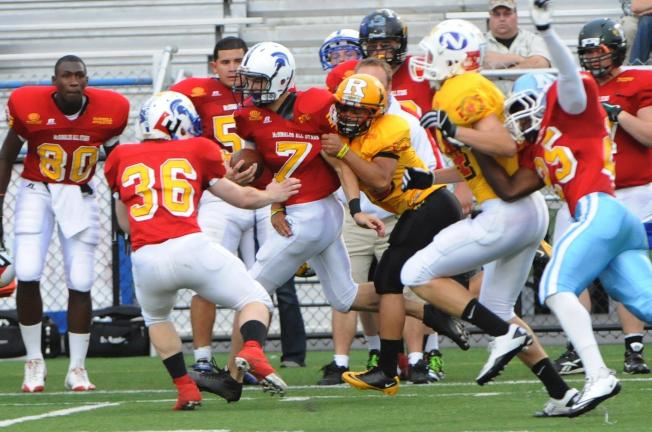 nancy scholz/times news Northern Lehigh's Jake Kern (7) is wrapped up from behind as he runs down the sideline for the Red team in the McDonald's All-Star football game on Thursday.