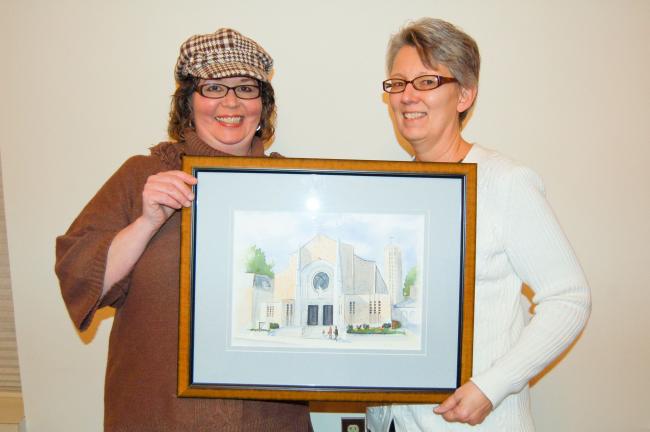 LINDA KOEHLER/TIMES NEWS Diane Danielson, Palmerton Area Library director, right, displays Paula Zelienka's of Palmerton, left, watercolor of The Sacred Heart Church. Artwork by local artists such as Zelienka's will be on display during the library…