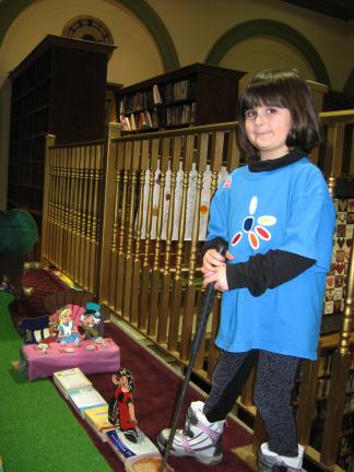 001 Daisy Girl Scout Nicollette McCabe lines up a putt on the "Alice in Wonderland" green during miniature golf at Library Palooza at the Palmerton Area Library.