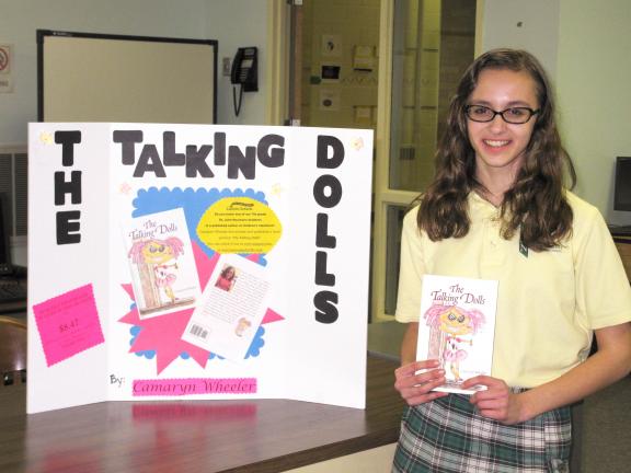 Special to the TIMES NEWS Camaryn Wheeler, a seventh-grade student at St. John Neumann Regional School's Palmerton campus, proudly holds a copy of the book she authored, "The Talking Dolls."