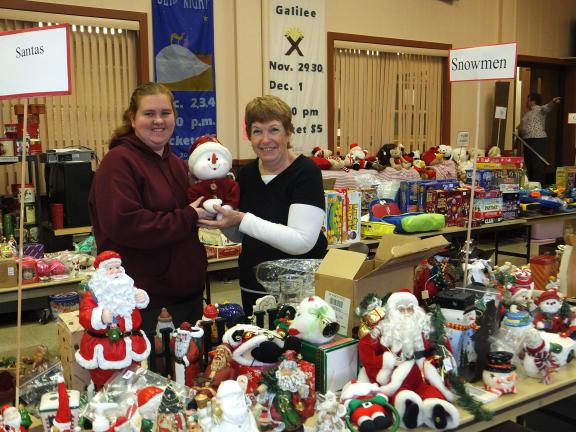 STACEY SOLT/SPECIAL TO THE TIMES NEWS Amanda Tertel, left, and Sarah Dalton, volunteers at the Trinity Thrift Store in Lehighton, help to set up the "snowman" display at the annual Christmas sale. The Trinity Thrift Store's Christmas sale will…