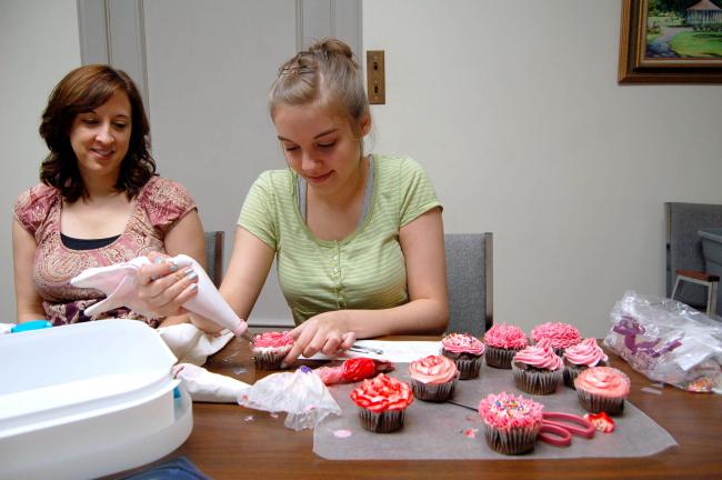 LINDA KOEHLER/TIMES NEWS Ragen Dunton lets her inner cupcake fashionista run wild as she learns different decorating ideas from Daughn Edwards. Her mother, Trina Dunton, looks on.