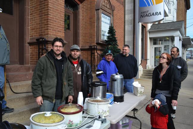 SHERI RYAN/SPECIAL TO THE TIMES NEWS ABOVE: The Rev. Jeremy Benack, left, and members of Grace Community Church shared hot chili, soup and cocoa with people at the second annual cash giveaway as part of Lansford Days of Christmas. With Benack are,…