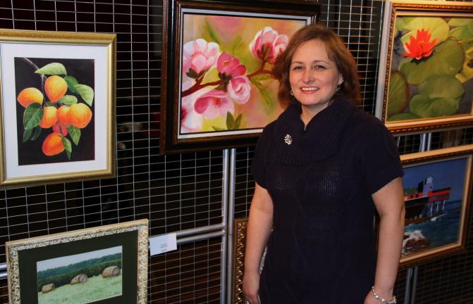 ANDREW LEIBENGUTH/TIMES NEWS Tamaqua native Sharon Miller-Reading stands with some of her work on disply at the TCAC. Her work will be on display until mid-February.