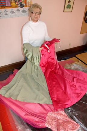 ANDREW LEIBENGUTH/TIMES NEWS Deb Davis displays two dresses already donated to TAFFN's annual Belle of the Ball event. She said they are still accepting donations.