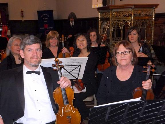 Concert master Hannes Dietrich, left, and violinist Patricia Adams, right, prepare for the start of the Bach and Handel Chorale's annual Easter Concert, which was accompanied by the 24-piece Festival Orchestra.