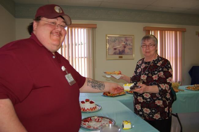 Gail Maholick/TIMES NEWS George Weaver, dietary manager at Mahoning Valley Nursing and Rehabilitation Center, offers a piece of cake to Emma Weaver a volunteer.