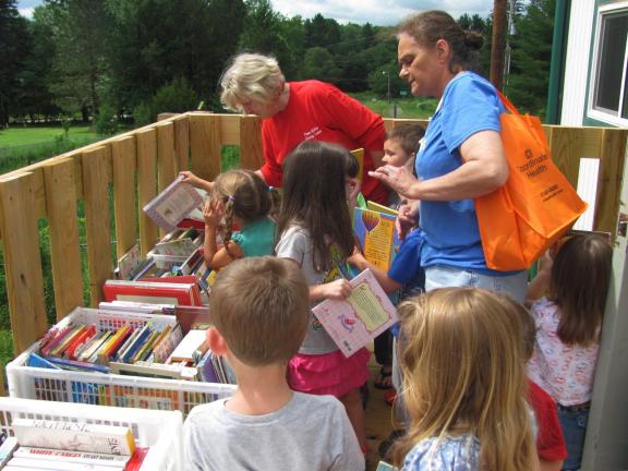 CAJETAN BERGER/SPECIAL TO THE TIMES NEWS ABOVE: Children from the Discovery Years day care center browse the children's section of the used book sale at he Penn-Kidder Library Center grand opening on Friday. BELOW: Michelle Ress, 34, right, and…