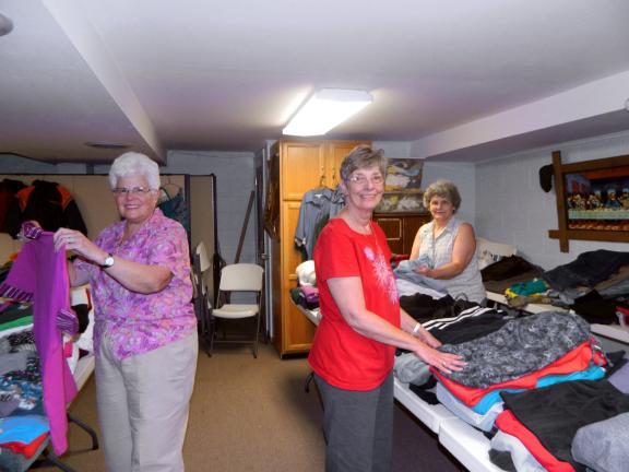 JUDY DOLGOS-KRAMER/SPECIAL TO THE TIMES NEWS Gail Malarky and Carol Lee O'Brien of Albrightsville and Shirley Leinthall of Summit Hill sort and fold some of the items donated to the fourth annual clothing Drive at St. Paul's Lutheran Church in…