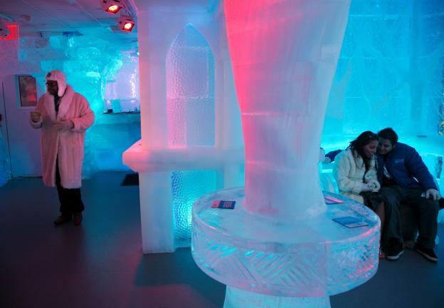 Kevin Parker, left, Ana Simon, center, and Eduardo Hernandez, right, visit the Minus 5 ice bar, on Monday, July 8, 2013 in New York. "On a hot day it's exactly what the city needs," said Parker, a real estate broker who plans to book his birthday…