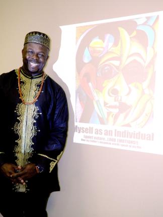 JUDY DOLGOS-KRAMER/SPECIAL TO THE TIMES NEWS Ibiyinka Olufemi Alao poses with a slide depicting his self-portrait.