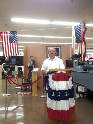 SPECIAL TO THE TIMES NEWS Jim Zbick, retired associate editor of the TIMES NEWS, stands a podium during unveiling of his John F. Kennedy collection at the Southwest Florida Military Museum in Cape Coral, Fla., Friday. In the background, in front of…
