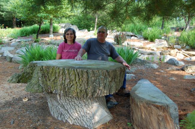 LINDA KOEHLER/TIMES NEWS Carol Sue and Kerry Gougher of Palmerton sit at a table made from a willow tree trunk that was on neighbor Terry Eckhart's property. Frank Hagar wanted to make a table out of it and encouraged Kerry to do the same. Kerry…