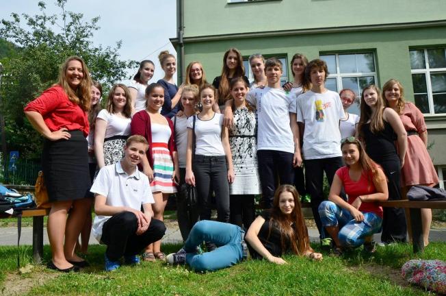 PHOTO COURTESY COURTNEY EVERETT Courtney Everett, standing front row center, in the white dress, poses with some of her  students and other teachers in the Slovak Republic. Everett recently returned to Slovakia where she will soon begin her third…