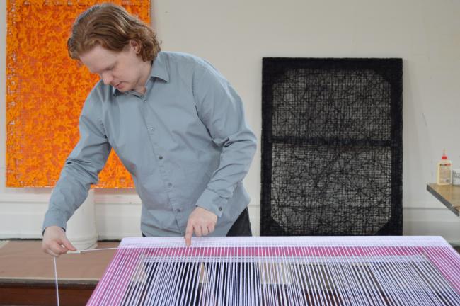 KATHY KUNKEL/TIMES NEWS Jeffrey Collins, Tamaqua's first Artist in Residence, wraps strands of acrylic yarn around a bare wooden frame before applying acrylic paint to add layers of texture to his work.
