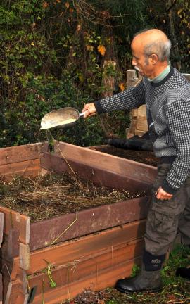This undated photo shows sprinkling soybean meal on the hay within this compost pile is one way to add nitrogen for quicker composting, in New Paltz, New York. (AP Photo/Lee Reich)
