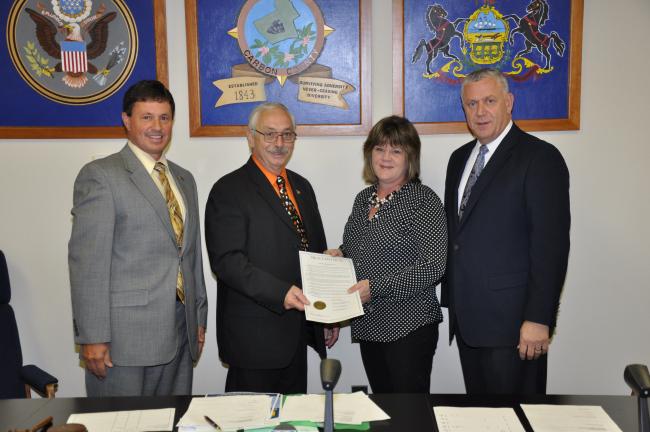 @$:AMY MILLER/TIMES NEWS Ellen Baca, coordinator of the Epilepsy Foundation Eastern Pennsylvania, second from right, accepts the proclamation naming November as Epilepsy Awareness Month in Carbon County, from Carbon County Commissioners Thomas J…
