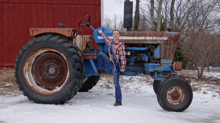 SPECIAL TO THE TIMES NEWS Carbon County Fair Queen Jordan Behrens poses next to her tractor on her family farm in Penn Forest Township. Jordan heads to Hershey today where she will represent the county in the annual Pennsylvania Fair Queen State…