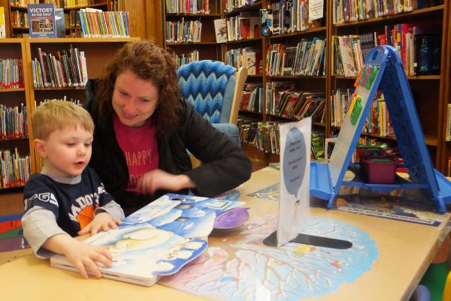 STACEY SOLT/SPECIAL TO THE TIMES NEWS Kristopher Andrew Rodgers Jr., 4, reads a book with mother Megan Rodgers in the Dimmick Memorial Library's children room. When asked what they "geek" or love about Dimmick, many younger patrons say they love the…