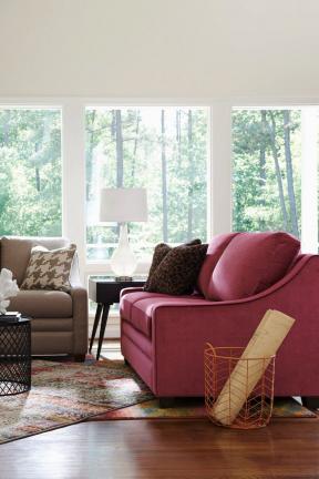 This photo provided by La-Z-Boy shows the Nightlife Premier Sofa in a rich plummy hue that is a statement piece. Let it anchor the room, and add complementary pattern as well as some neutrals to provide balance and cohesion. (La-Z-Boy via AP)