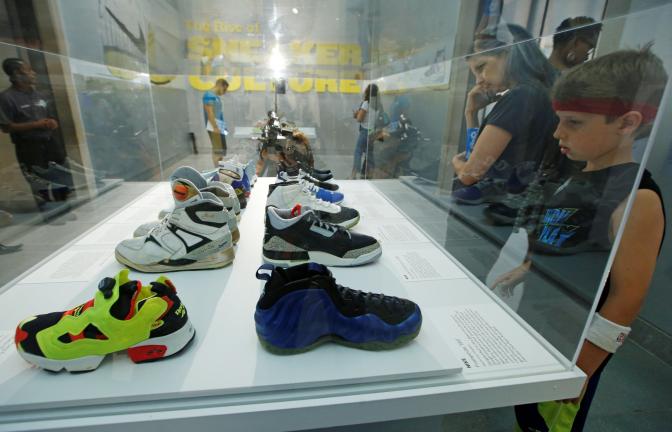 An array of colorful sneakers are displayed at "Out of the Box: The Rise of Sneaker Culture" exhibit at the Brooklyn Museum of Art in New York, Wednesday, July 8, 2015. (AP Photo/Kathy Willens)