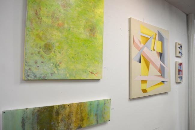 Michelle Neifert's acrylic paint and canvas hang along side Ryan Hnat's Geometric abstraction piece in the gallery.