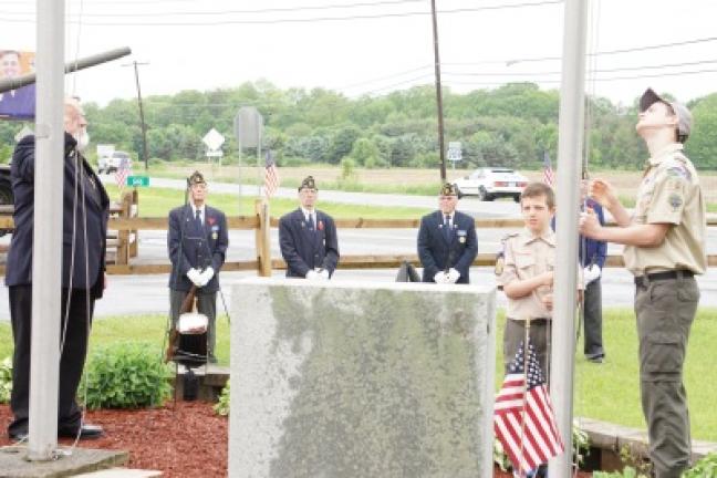 From left, Bishop James Mills, chaplain at Gilbert American Legion Post 927, leads the flag ceremony Monday with Benjamin Bush, 11, and Jonathon Smith, 14, both of Troop 102 of Kunkletown on Monday. MARTA GOUGER/TIMES NEWS