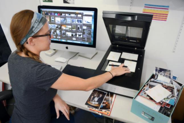 Imaging specialist Erin McClintic works in the lab at Phototronics in Winnetka, Illinois, digitizing and archiving a shoe box of customer photographs, right. PHOTOTRONICS VIA AP