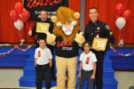 AMY ZUBEK/TIMES NEWS Jim Thorpe Police Chief Joseph Schatz, back left, and Sgt. David Midas of the Carbon County Sheriff's Department, back right, receive certificates of appreciation from the students at St. Joseph's Regional Academy for their…