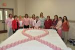 AMY ZUBEK/TIMES NEWS Organizers of the Fifth Annual Horizon of Hope luncheon gather around a pink breast cancer awareness ribbon, made out of Longaberger measuring cups, to show their support of Jessyca Fredericks, center, who is currently battling…