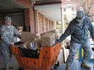 STACEY SOLT/SPECIAL TO THE TIMES NEWS Paul Shollenberger, left, and SSG Chuck Francisco of the Lehighton Armory guide a mail cart onto a shipping truck. More than 5,600 pairs of shoes were collected during the third annual "Let Them Walk in Our…