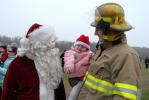 RON GOWER/TIMES NEWS Two-year-old Adrian Wentz of Summit Hill, held by his stepfather, Stephen Becker, doesn't seem too impressed by Santa during his arrival at the Ginder Field in Summit Hill. Santa arrived by helicopter and Becker, a member of the…
