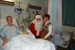 TERRY AHNER/TIMES NEWS Patient Herman Silfies is all smiles as his daughter, Debbie Siekonic, sits on the lap of Santa Claus during his visit to Palmerton Hospital on Tuesday.