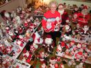 ANDREW LEIBENGUTH/SPECIAL TO THE TIMES NEWS Erma Warne of New Ringgold stands in the middle of her parlor surrounded by hundreds and hundreds of Kriss Kringles. She holds the first animated Santa and Mrs. Claus she purchased almost 20 years ago.