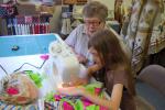 RIGHT: Jane Heckman watches over Shannon Beltz as she stitches a border onto her quilt. Shannon, who is in the sixth grade, is home-schooled.