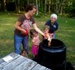 Master Gardener Julie Foley, right, helps a mother and her children add their contributions to the compost bin during acomposting event. There will be another composting event at Mauch Chunk Lake Park this Saturday.