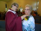 JUDY DOLGOS-KRAMER/SPECIAL TO THE TIMES NEWS Clara Moyer pins a corsage on Anna Moser at St. Paul's Lutheran Church in Albrightsville Sunday. Moser was honored for her nearly 60 years of service to the church.