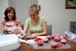 LINDA KOEHLER/TIMES NEWS Ragen Dunton lets her inner cupcake fashionista run wild as she learns different decorating ideas from Daughn Edwards. Her mother, Trina Dunton, looks on.