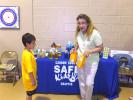 Stacey Solt/TIMES NEWS Mindy Graver, chairperson of Carbon County Safe Kids, asks Nicholas Zeigenfuss and his classmates if they can tell the difference between Arm & Hammer baking soda and carpet cleaner, showing them only the back of the package…